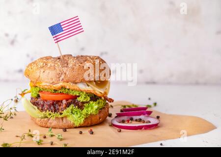 Leckere Burger und Gewürze auf hellem Hintergrund Stockfoto