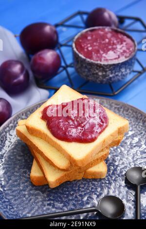 Brotscheiben mit köstlicher hausgemachter Pflaumenmarmelade auf Holz Hintergrund Stockfoto