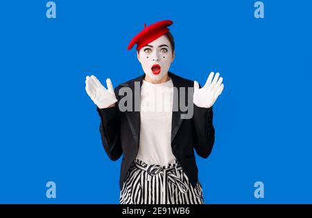 Schockierte weibliche Pantomimist auf farbigem Hintergrund Stockfoto
