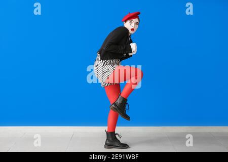 Verängstigte weibliche Pantomimist auf farbigem Hintergrund Stockfoto