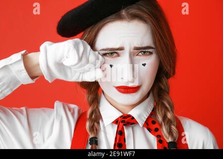 Weinende weibliche Pantomimist auf farbigem Hintergrund Stockfoto