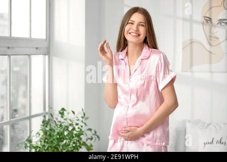 Junge schwangere Frau, die Vitamine zu Hause Stockfoto