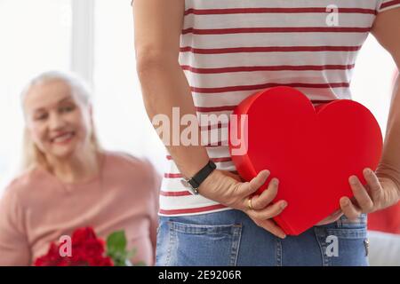 Reifer Mann begrüßt seine Frau am Valentinstag zu Hause Stockfoto