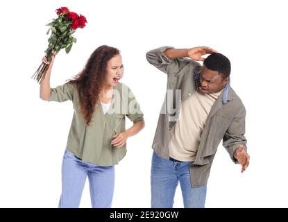 Erschrocken afroamerikanischen Mann und seine zornige Freundin mit Blumen erhalten Auf weißem Hintergrund Stockfoto