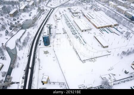 Luftaufnahme von Straßenbahndepot im städtischen Industriegebiet. Winterstadtbild. Drohnenfoto Stockfoto