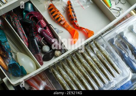 Kunststoff-Angelkasten mit Kunstködern. Verschiedene Köder zum Fang von Raubfischen. Selektiver Fokus. Stockfoto