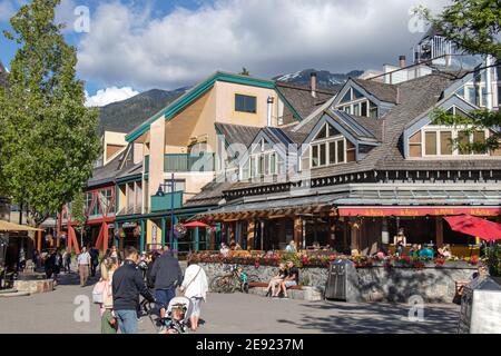 Whistler, Kanada - Juli 5,2020: Whistler Village voller Menschen an einem sonnigen Tag mit Blick auf die Berge im Hintergrund Stockfoto