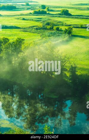 Morgennebel über Wiese und Fluss Stockfoto