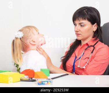 Ein pädiatrischer HNO-Arzt untersucht die Mandeln eines kleinen Mädchens im Alter von 3 Jahren. Das Konzept der Halsschmerzen bei Kindern und der Trea Stockfoto