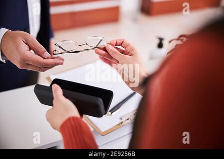 Männlicher Kunde kauft verschreibungspflichtige Gläser in einem optischen Geschäft Stockfoto