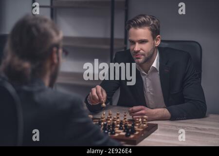 Lächelnder kluger Mann mit Schachfigur in der Hand Stockfoto