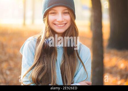 Lächelndes Mädchen mit Kopfhörern in der Natur Stockfoto
