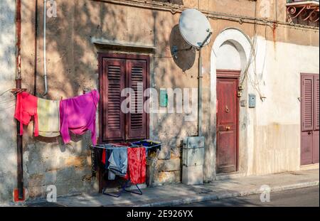 Blick auf ein altes Haus mit Waschküche auf dem Bürgersteig, in der Via Cappuccini, im Zentrum von Palermo, der Hauptstadt von Sizilien. Stockfoto