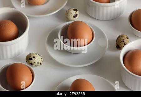 Ostern abstrakt minimalistisches Konzept Muster mit Eiern und Keramik weißen Tellern und Geschirr auf weißem Hintergrund, geometrische isometrische moderne Kunst Design Stockfoto