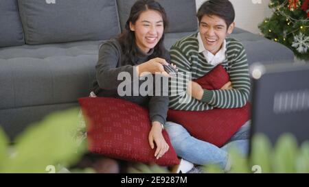 Glücklich asiatische schön junge Familie paar Mann und Frau genießen Im Wohnzimmer Winter zu Hause Fernsehen Fernsehen Unterhaltung Oder Film zusammen Stockfoto