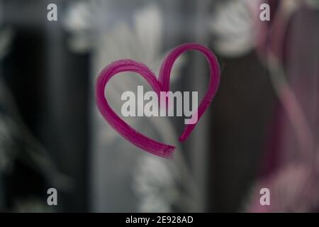 Herz auf Glas mit Lippenstift gemalt. Valentinstag. Liebe und Romantik. Herz gezeichnet von einem Lippenstift. Angezeigt. Lippenstift mit Beschriftung Stockfoto