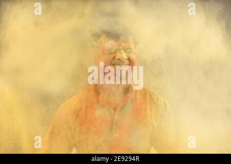 Mann feiert Holi mit trockener Farbe Stockfoto