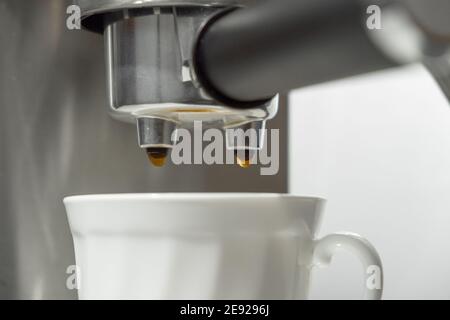 Kaffeemaschine Portafilter Nahaufnahme während des Prozesses der Ausgießung von Kaffee In eine Tasse Stockfoto