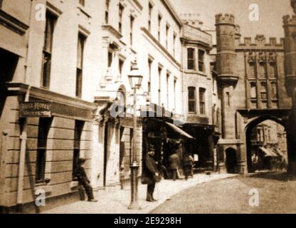 Ein altes Foto aus Scarborough, North Yorkshire, Großbritannien, zeigt die ehemalige (wiederaufgebaute) Newborough Bar, die Teil der alten Stadtmauer war. Das Bull Inn befindet sich auf der linken Seite. Die Bar mit ihrem Torbogen, in dem sich das Stadtgefängnis befindet, wurde 1843 mit Türmchen umgebaut. In der Ferne, jetzt außer Sichtweite, ist Scarborough Castle und seine Wände, die während der Bombardierung von Scarborough durch deutsche Kriegsschiffe im Ersten Weltkrieg stark beschädigt wurden. Stockfoto