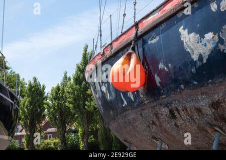 Orangefarbene gebeulte Boje auf einem alten verwitterten Segelboot Stockfoto