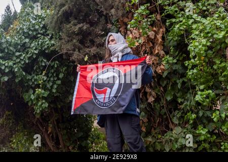 Ein junger Israeli hält eine Flagge der Antifaschistischen Aktion, einem linksextremen, antifaschistischen Netzwerk in Nordeuropa, während einer Demonstration gegen den israelischen Ministerpräsidenten Benjamin Netanjahu vor dem offiziellen Wohnsitz des Premierministers in Jerusalem am 29. Januar 2021, bei der Netanjahu wegen Betrugs zum Rücktritt aufgefordert wurde, Bestechung und Vertrauensbruch. Stockfoto