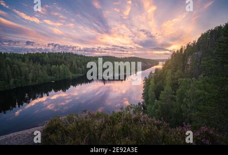 Malerische Wald- und Seenlandschaft mit ruhiger Stimmung und bunt Sonnenuntergang am Sommermorgen in Finnland Stockfoto