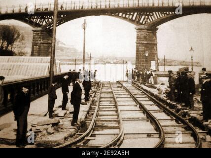 Ein altes Foto aus Scarborough, North Yorkshire, Großbritannien, zeigt die neu angelegten Straßenbahnschienen unter der Valley Bridge mit Arbeitern, Aufsehern und Beobachtern, die sich für ein Foto des fertiggestellten Abschnitts versammeln. Scarborough Bay und Hafen sind im Hintergrund zu sehen. Baubeginn war am 12th. Oktober 1903 (Eröffnung am 6th. Mai 1904) Stockfoto