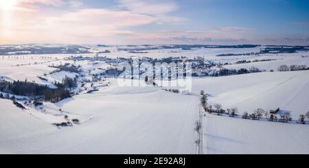Luftaufnahme der Landschaft mit Dorf Puklice, Wohngebäude im Winter. Winterlandschaft schneebedeckten Feld und Bäume in der Landschaft. Tschechische Re Stockfoto