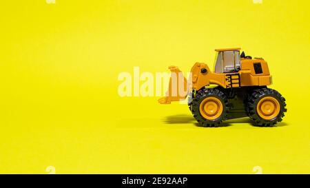 Spielzeug Schreibmaschine Traktor Bulldozer auf einem gelben Hintergrund. Spielzeug für Kinder. Stockfoto