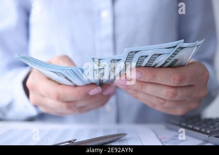 Frau, die in der Nähe des Arbeitsplatzes Geld zählt Stockfoto