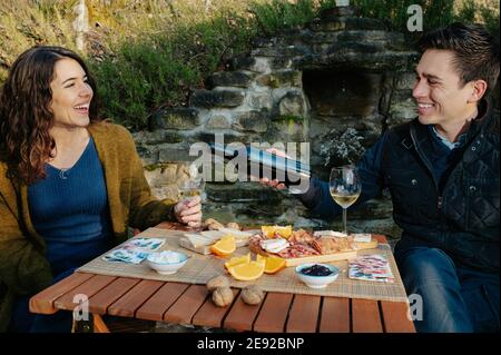 Liebevolles Paar mit einem Mittagessen im Freien im Garten und Weinprobe Stockfoto