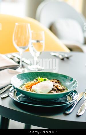 Rinderramen-Suppe mit pochiertem Ei und Gemüse bei a Restaurant Stockfoto