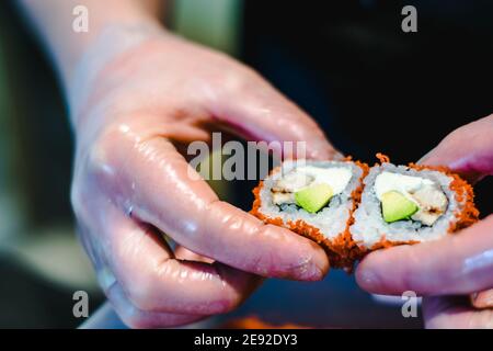 Sushi-Chef macht Maki- und Sashimi-Sushi an einem Sushi Restaurant Stockfoto