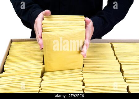 Mann in schwarz einheitliche Verpackung gelb gepolsterte Blase Umschläge in Ein großer Karton Stockfoto