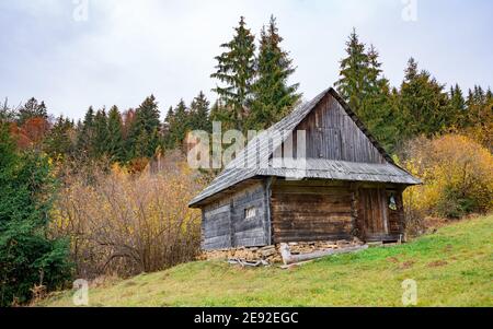 Kleines altes Haus in einem kleinen schönen Tal mit Grün Frische Wiesen und bunte Herbstwälder Stockfoto