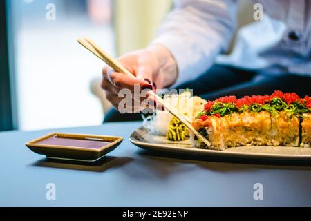Frau, die Sushi in einem Restaurant isst Stockfoto