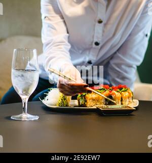 Frau, die Sushi in einem Restaurant isst Stockfoto
