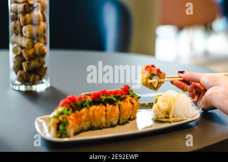 Frau, die Sushi in einem Restaurant isst Stockfoto
