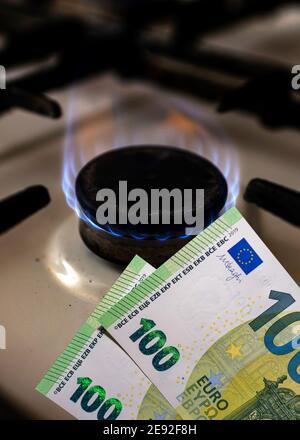 Geld und Herd.Brennende Flamme Ofen und hundert Rechnungen zwei Stückelungen.Close up. Stockfoto