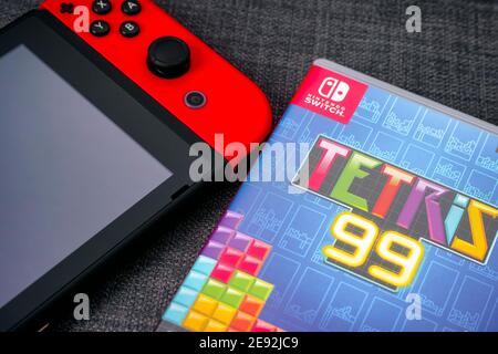 Tambow, Russische Föderation - 01. Januar 2021 Tetris 99 Videospielbox und Nintendo Switch Videospielkonsole auf grauem Hintergrund. Stockfoto