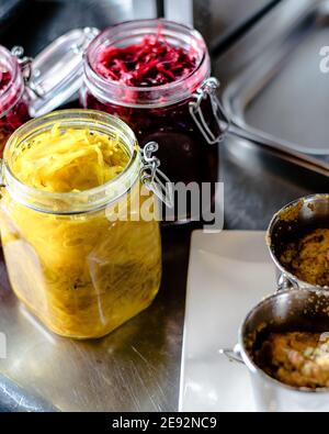 Hecht-Cutlet mit Kürbissauce und fermentierten Kohl in verschiedenen Farben in einem Restaurant Stockfoto