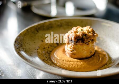 Hecht-Cutlet mit Kürbissauce und fermentierten Kohl in verschiedenen Farben in einem Restaurant Stockfoto