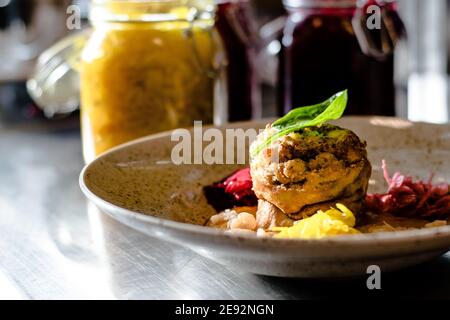 Hecht-Cutlet mit Kürbissauce und fermentierten Kohl in verschiedenen Farben in einem Restaurant Stockfoto