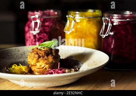 Hecht-Cutlet mit Kürbissauce und fermentierten Kohl in verschiedenen Farben in einem Restaurant Stockfoto