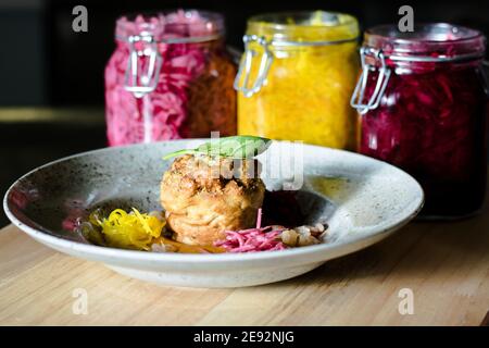 Hecht-Cutlet mit Kürbissauce und fermentierten Kohl in verschiedenen Farben in einem Restaurant Stockfoto