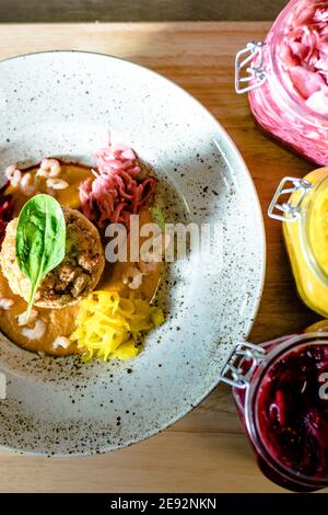 Hecht-Cutlet mit Kürbissauce und fermentierten Kohl in verschiedenen Farben in einem Restaurant Stockfoto