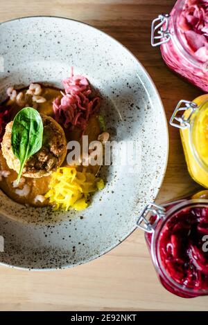 Hecht-Cutlet mit Kürbissauce und fermentierten Kohl in verschiedenen Farben in einem Restaurant Stockfoto