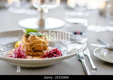 Hecht-Cutlet mit Kürbissauce und fermentierten Kohl in verschiedenen Farben in einem Restaurant Stockfoto