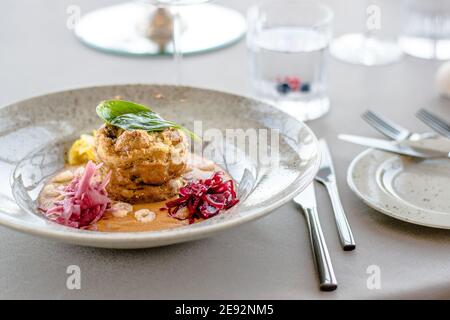 Hecht-Cutlet mit Kürbissauce und fermentierten Kohl in verschiedenen Farben in einem Restaurant Stockfoto