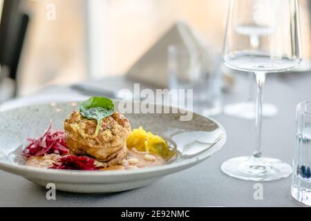 Hecht-Cutlet mit Kürbissauce und fermentierten Kohl in verschiedenen Farben in einem Restaurant Stockfoto